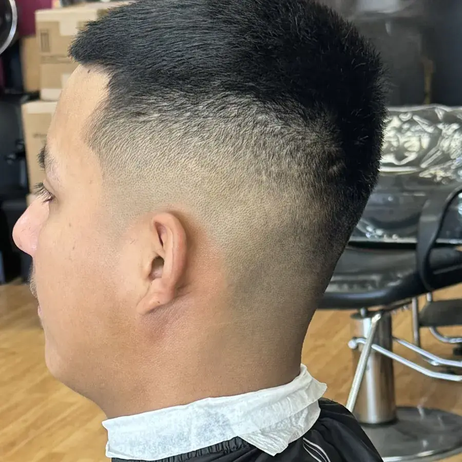High skin fade seen from the side, blended from bare skin into a short textured top